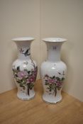 A pair of large decorative vases, hand painted in an oriental style with a striking peonies design