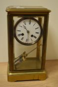 A late 19th Century four glass mantel clock, the brass case enclosing an enamelled roman dial with