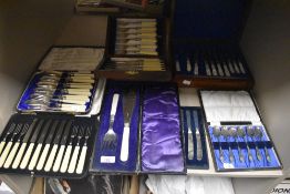 An assortment of boxed cutlery and flatware including a set of butter knifes, teaspoons, mother of