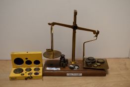 A set of Edwardian Arnold Precision postal scales with weights mounted upon a stepped oak base,