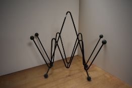 An Atomic 1950's magazine rack made of metal wire painted black with four green balls at the top