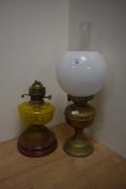 Two oil lamps, one having brass base, glass chimney and milk glass shade, the other having a
