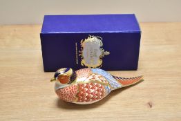 A Royal Crown Derby bone china pheasant paperweight, decorated in a stylised Imari palette with gold