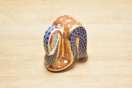 A Royal Crown Derby bone china snake paperweight, decorated in a stylised Imari palette with printed