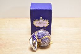 A Royal Crown Derby bone china badger paperweight, decorated in a stylised Imari palette with gold