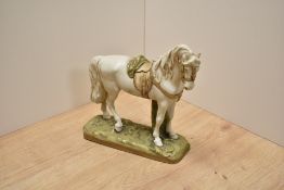 A Royal Dux porcelain horse study number 1011, modelled standing with saddle and blanket, in typical