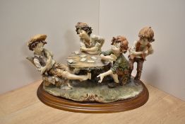 A Capodimonte cast-resin figural group 'The Cheats' modelled as children playing cards around a