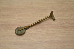 A vintage brass pie jigger / pie wheel.