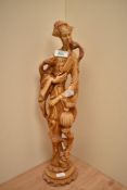 A large cast resin or ivory style figural study of a robed female with exotic birds, measuring