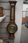 An early 20th Century oak barometer with silvered dial, measuring 60cm high