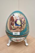 A Continental porcelain footed egg trinket box, decorated with vignettes of floral arrangements