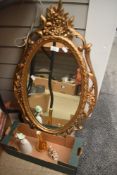 A 20th Century reproduction giltwood mirror, of oval form, measuring 70cm high, together with a