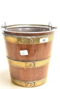 A 20th century 'coopered' oak bucket form planter with swing over handle and removable brass