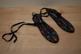A pair of Chinese silk slippers with bright floral embroidery.