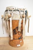 An African animal skin drum, with carved decoration to body.