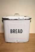 A mid-20th Century square enamelled bread bin and lid, black on white, measuring 28cm tall