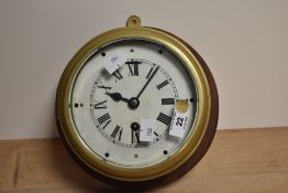 A vintage brass cased bulkhead clock, of traditional design with Roman hours and single winding