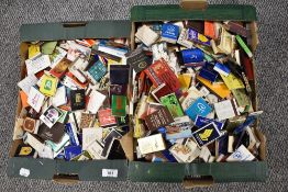 Two boxes of assorted collectable matchboxes from various brands and designs.