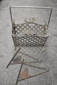 A vintage wrought iron magazine rack and two plant hangers having cat decoration.