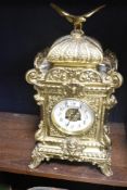 An ornate French brass bracket clock having an eagle cermounted and cushion moulded top with