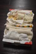 A carton of assorted lace and embroidered table linen including crotched doilies.