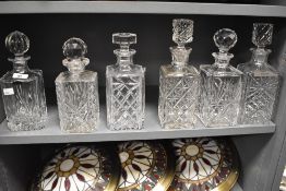 Six 19th/20th Century English crystal glass decanters and stoppers of square form, one bearing a