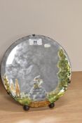 An early 20th Century circular bevelled edge mirror with hand painted design and raised on an