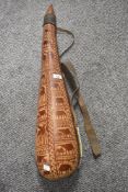 A large gourde, with carved animals depicted to the body with beaded strap.