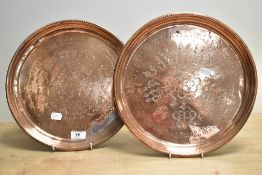 A pair of copper Arts and Crafts design trays of circular form, having a stylised engraved design,