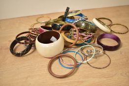 An assortment of costume bracelets including wooden bangles, statement bangles and paste set bangles