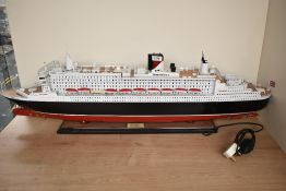 A wooden kit built scale model, Cunard Queen Mary 2, on fitted stand, length 100cm