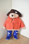 A Gabrielle Designs Paddington Bear wearing brown hat, red jacket and blue Dunlop wellingtons,