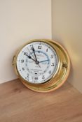 A Hesmle, Quartz brass bulkhead clock with numbered dial, spade hands and red seconds hand, How,