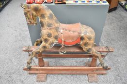 A Victorian hand carved Rocking Horse having leather saddle and stirrups, missing mane and tail,