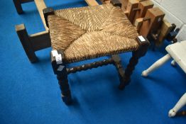 A traditional seagrass stool on turned frame