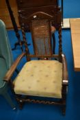 A traditional oak rocking chair having cane back and modern upholstered seat