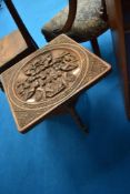 A tribal art carved occasional table having pictorial carvings to top and elephant supports