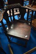 A 19th Century oak corner chairs having carved arms and vase splat backs