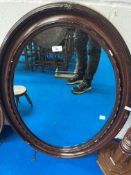 An mahogany ramed oval wall mirror