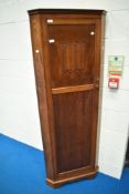 An early 2th Century oak corner hall robe with line fold decoration to panelled door, height approx.