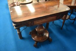 A 19th Century rosewood fold over tea tableon William IV style base with roundel platform