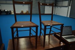 A pair of Edwardian mahogany bedroom chairs having canework seats