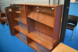 A pair of vintage teak bookcases with cupboards to base