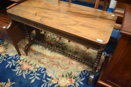 A Victorian mahogany and walnut sofa style side table having turned supports and stretcher