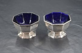 A pair of early 20th century silver condiment pots, of pedestal octagonal form, raised on