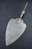 A Victorian silver presentation trowel, having an engraved decorative floral border with a central