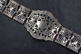 A 1920s silver plated articulated belt, having panels of pierced scroll motif with a banded edges,