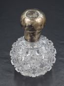 A cut glass scent bottle, having a silver screw-off cover filled with cork and rubbed hallmarks,
