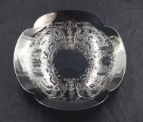 An Elizabeth II silver dish, of quatrefoil lobed form with decorative scroll engraving to the