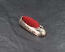 A 20th century silver novelty pin cushion modelled as a ballet shoe having red velvet to the centre,
